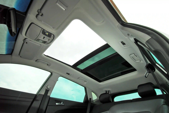 Interior view of a car with panoramic sunroof and seatbelt features, highlighting comfort and safety for auto service customers.