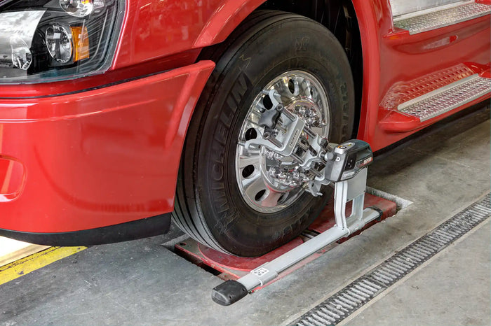 Truck wheel alignment in progress with Hunter alignment equipment on a Michelin tire at an auto service center.