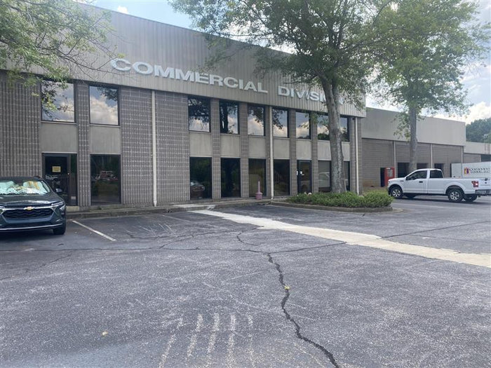 Exterior of Porterfield Tire Discounters Commercial Division building with parked service vehicles and clear signage.