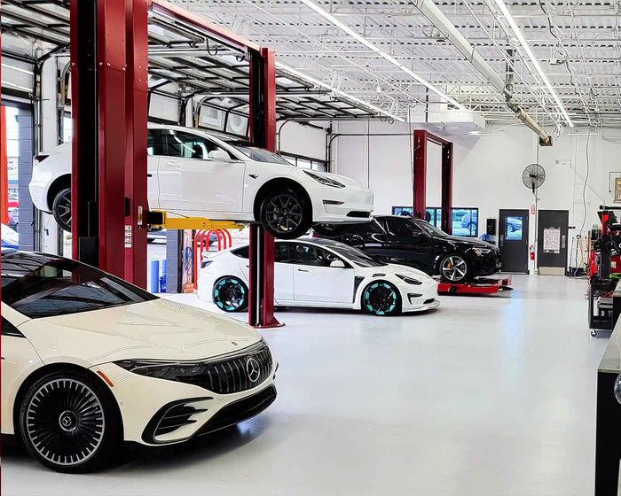 EV service bay with Tesla and Mercedes vehicles on lifts and in queue for electric vehicle maintenance at TD/EV.