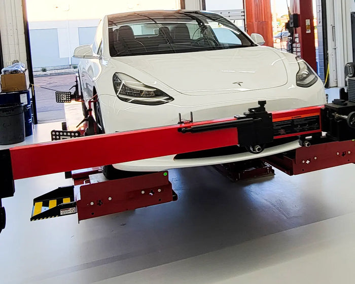 Tesla undergoing precision wheel alignment on a Hunter alignment rack at TD/EV in Fields Ertel.