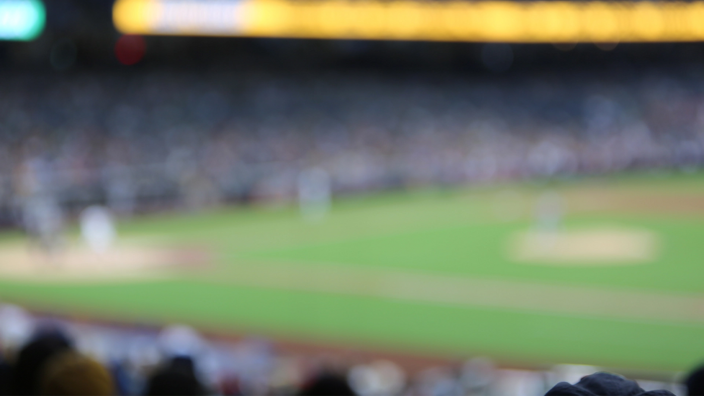 Baseball field scene with players and stadium lights captured in blurred focus.