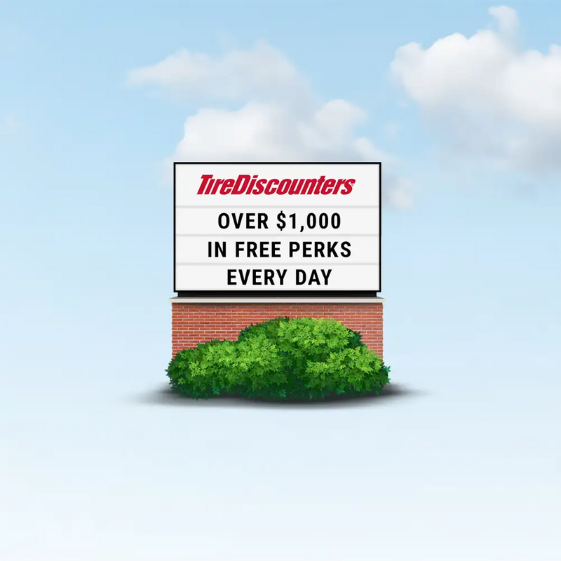 Tire Discounters roadside sign highlighting daily $1,000 in extras with tire purchase.