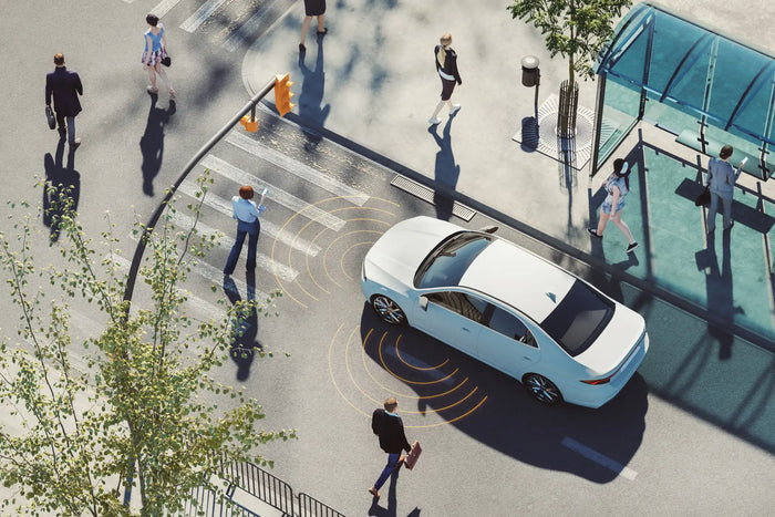 Autonomous vehicle detects pedestrians at crosswalk using ADAS safety sensors and smart detection systems.