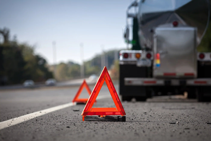 Emergency roadside triangle reflectors behind a commercial truck, indicating a vehicle breakdown or roadside assistance need.