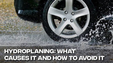 Car wheel splashing through standing water