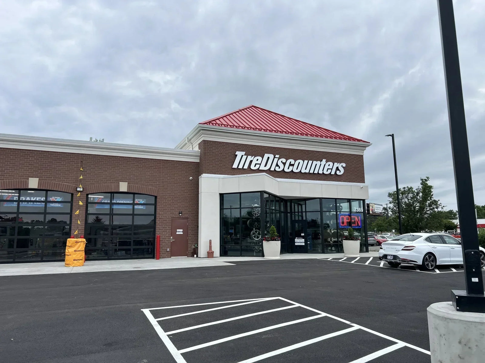 Exterior of a newly rebuilt Tire Discounters store in Cincinnati, Ohio, featuring expanded service bays, updated parking, and a modern storefront.