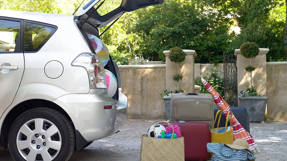 Vehicle loaded with suitcases and beach essentials preparing for a summer road trip