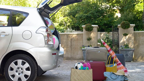 Vehicle loaded with suitcases and beach essentials preparing for a summer road trip