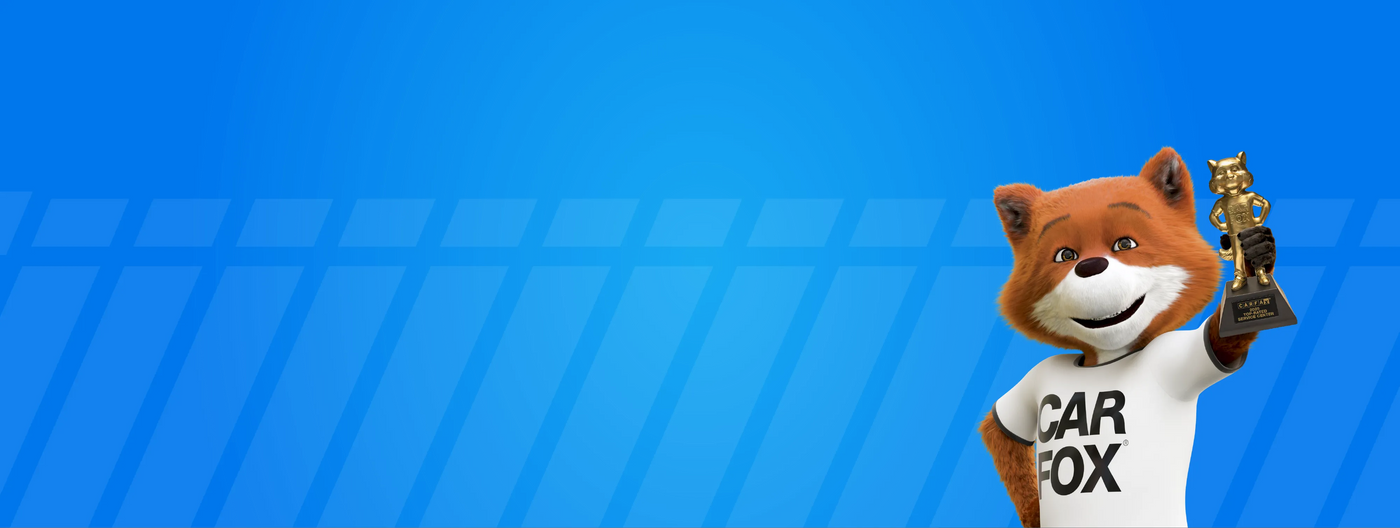 CARFAX fox mascot on blue background holding a trophy, symbolizing trusted vehicle history reports for used car buyers.