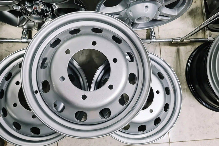 Close-up of silver steel car rims on display, showcasing new wheel options for tire and auto service replacement.
