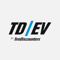 TD|EV logo featuring bold black text split by a striking blue slash, with "by Tire Discounters" beneath — representing Tire Discounters' specialized line of electric vehicle services.