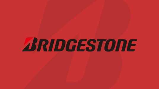 Bridgestone logo on a bold red backdrop, showcasing the brand’s sleek, modern typography and signature “B” emblem — a symbol of innovation, performance, and global reliability in tire manufacturing.