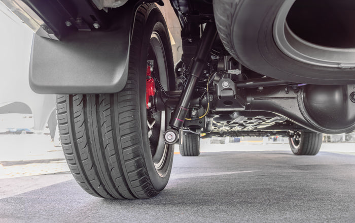Close-up of vehicle suspension and rear tire tread — expert suspension services available at Tire Discounters for a smoother ride.