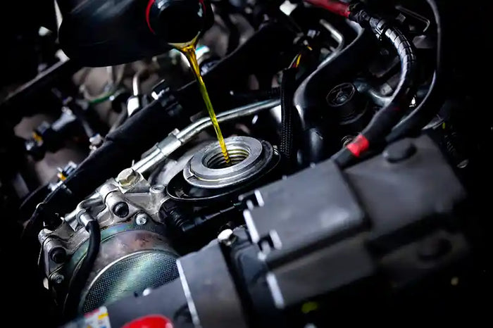 Engine oil being poured into a car engine during an oil change service at Tire Discounters.
