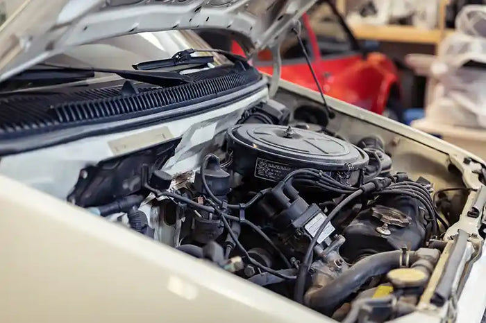 Close-up of a car engine under an open hood during auto repair or maintenance service.