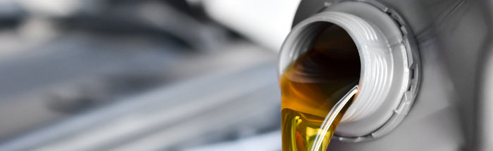 Close-up of motor oil being poured during an oil change — full-service oil change and maintenance at Tire Discounters.