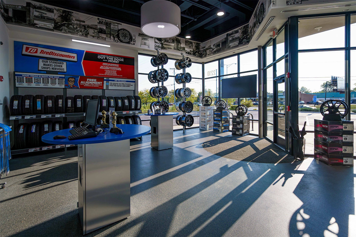 Tire Discounters showroom featuring tire displays, custom wheels, service counters, and natural light through large front windows.